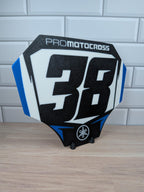 Custom motocross number plate replica with personalized rider number and name on a stand